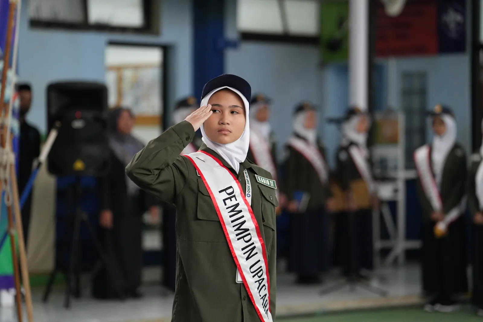 SMP Alfa Centauri student ceremony leader saluting solemnly during school assembly.